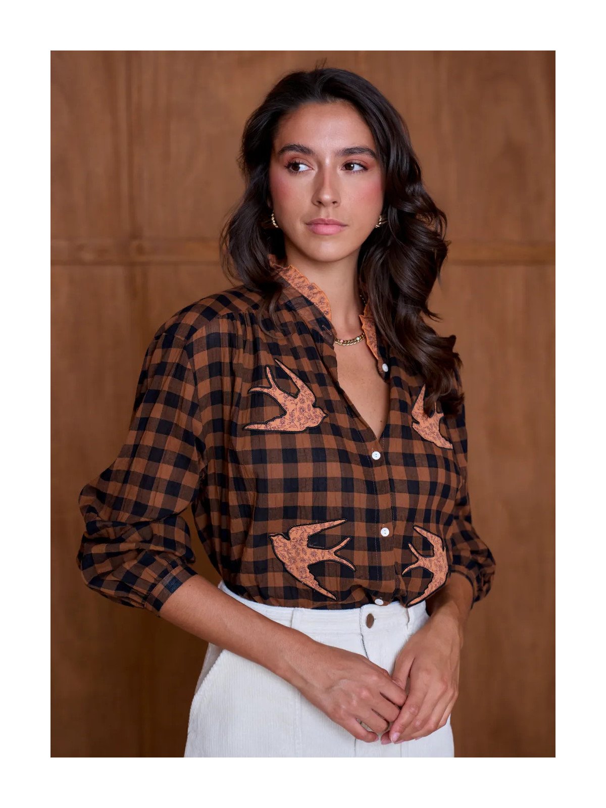 Women's loose-fitting blouse with a gathered neckline and appliqué details