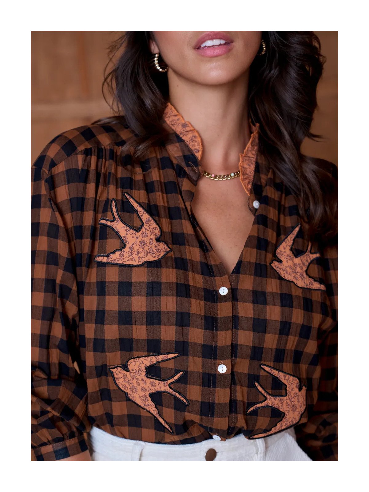 Women's loose-fitting blouse with a gathered neckline and appliqué details